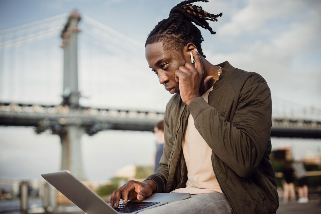 A field marketer on the phone while typing on a laptop
